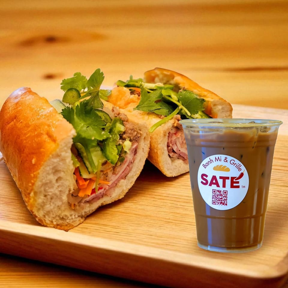 A SATE Banh Mi & Grille Vietnamese sandwich and an iced coffee with the restaurant's logo.