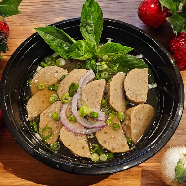 SATE Banh Mi & Grille's Vietnamese noodle soup with sliced meat, red onions, and green herbs.