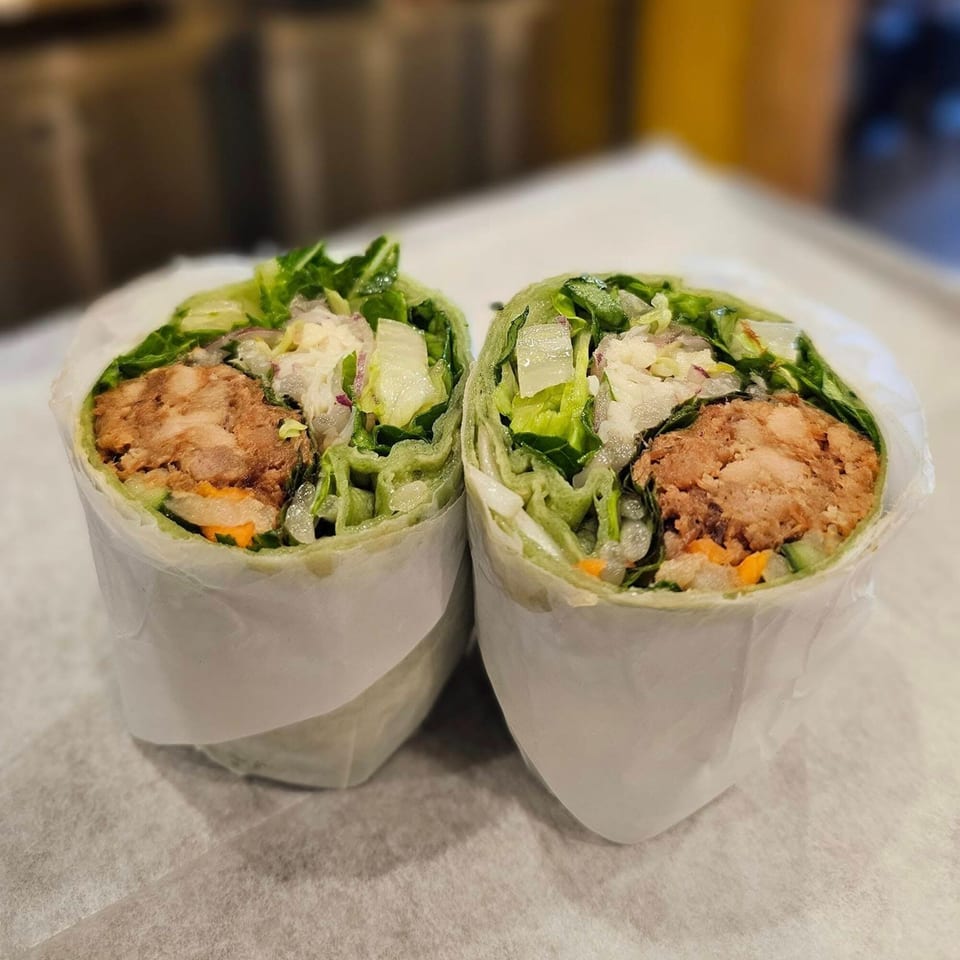 Two halves of a Vietnamese spring roll, filled with meat, lettuce, and rice vermicelli.